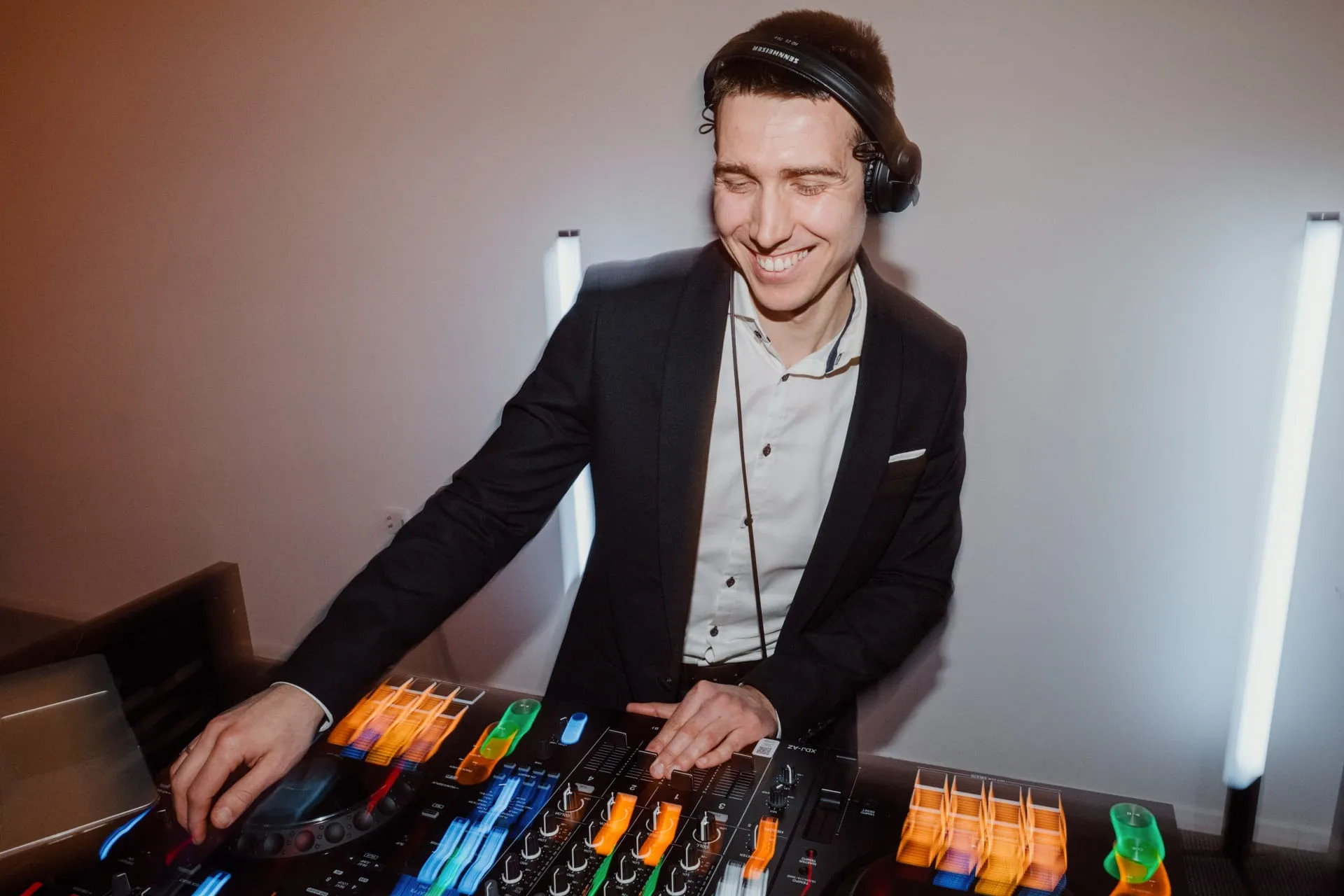 DJ Symart smiling at the decks at a wedding