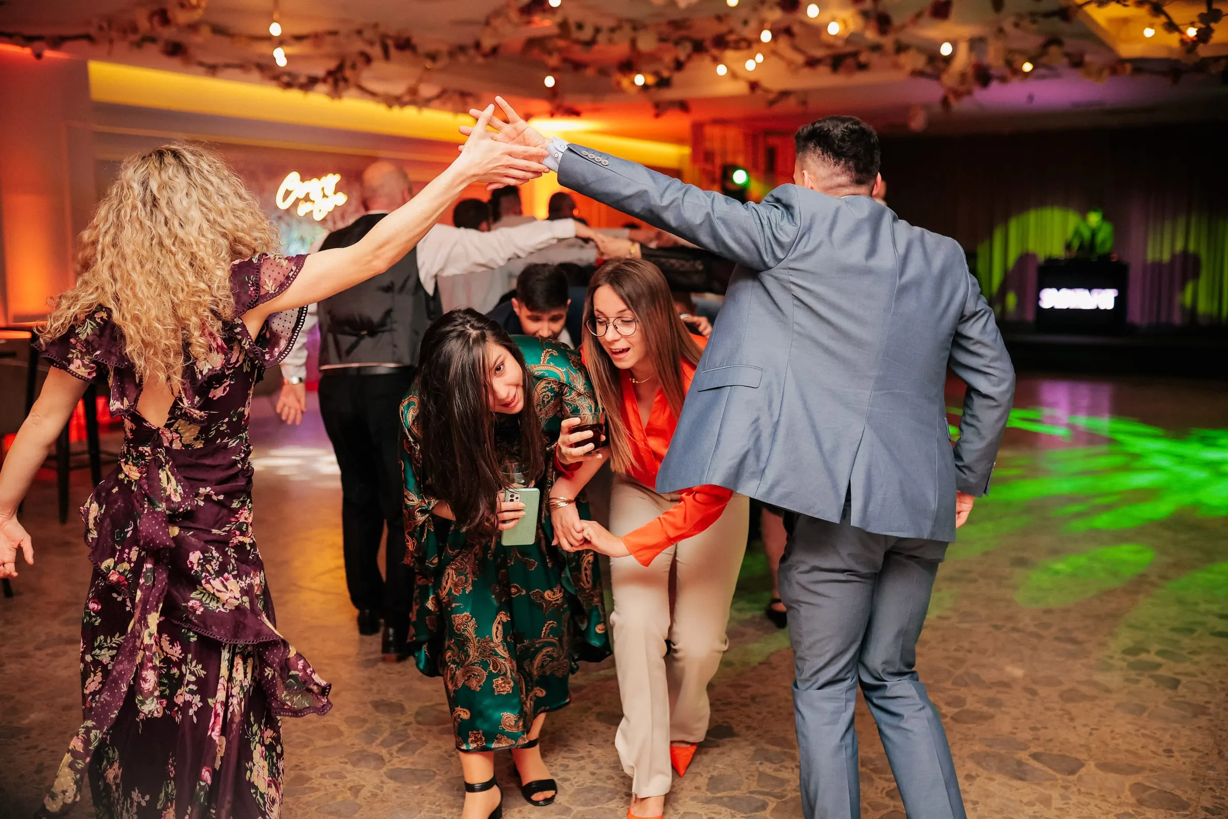 Wedding guests dancing together under coloured lights at Flores in Zagreb