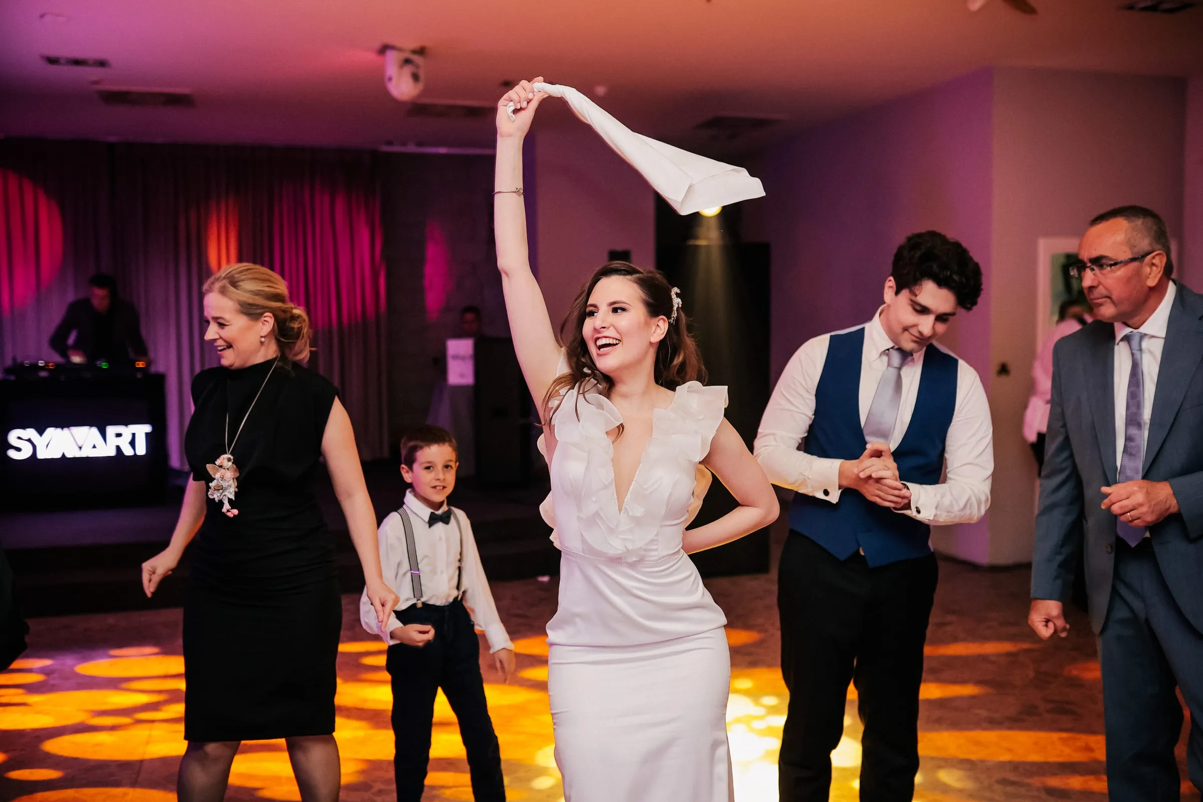 A bride waving a napkin on a full dance floor at Flores in Zagreb