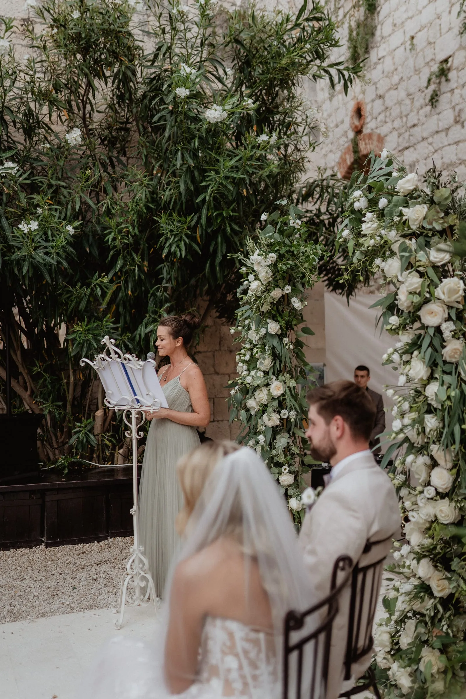 A wedding ceremony under a floral arch at Fort George on Vis