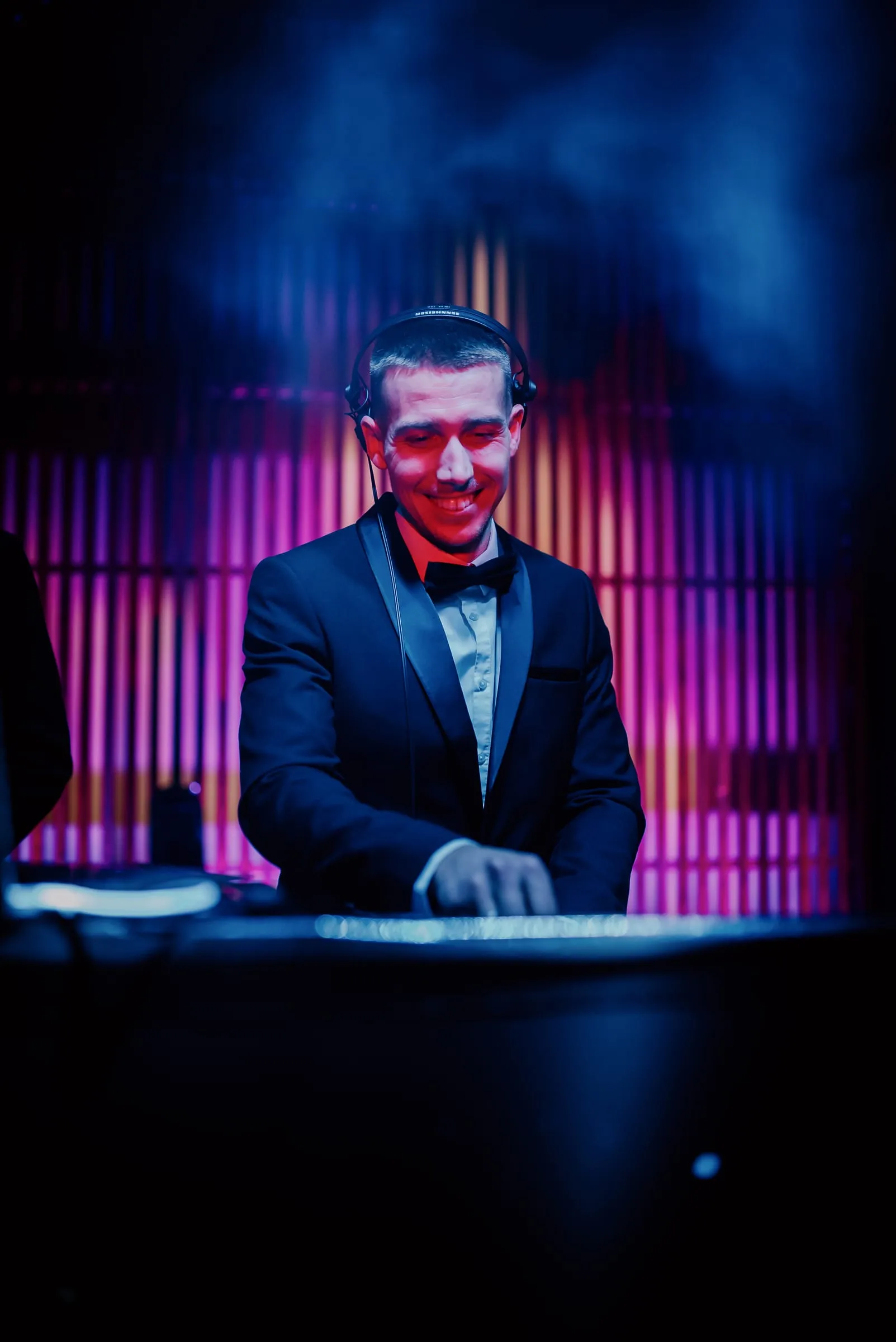 DJ Symart smiling at the decks in blue light at Mansion in Zagreb