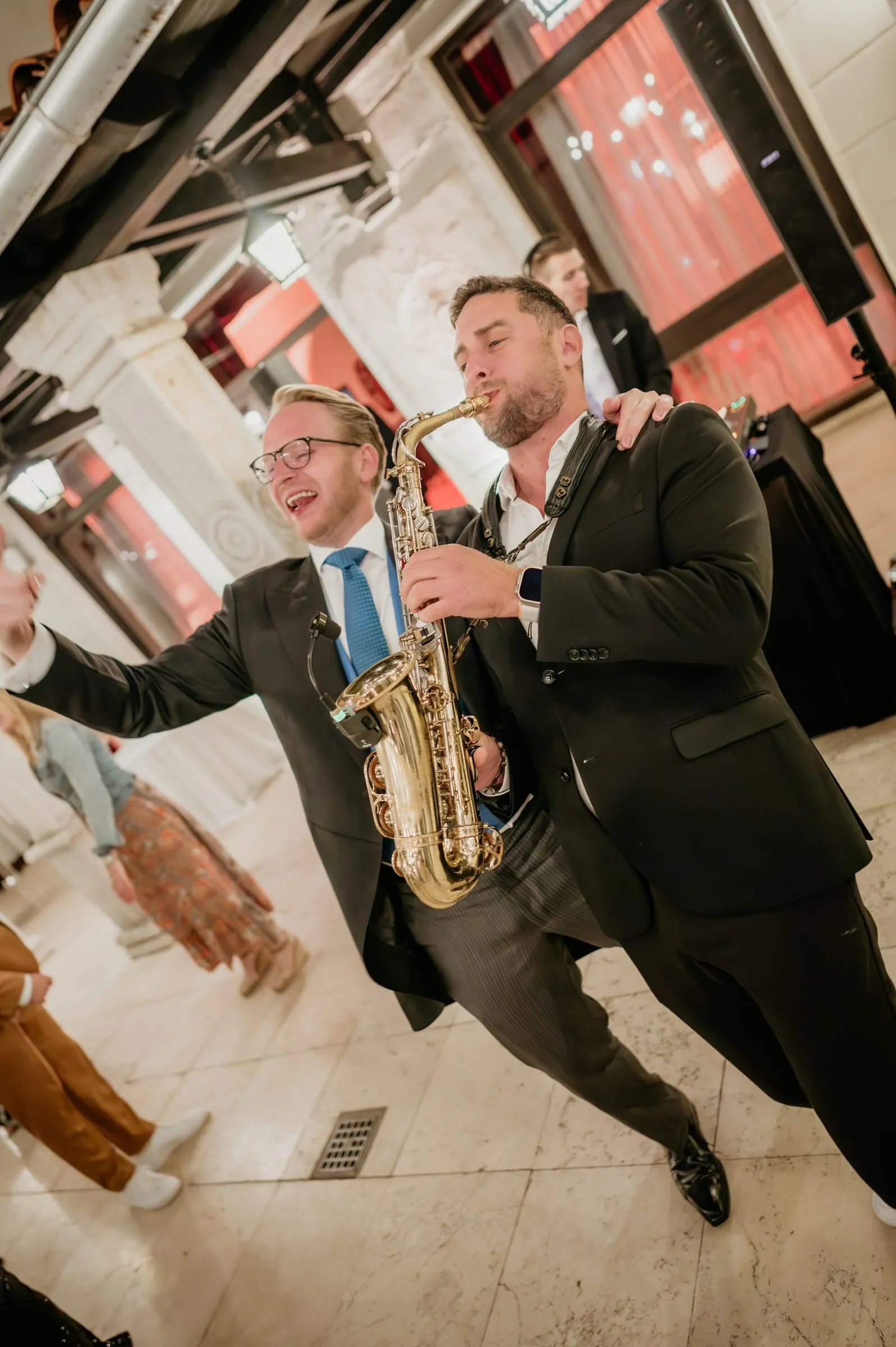A saxophonist playing as a guest dances beside him at a wedding on Red Island