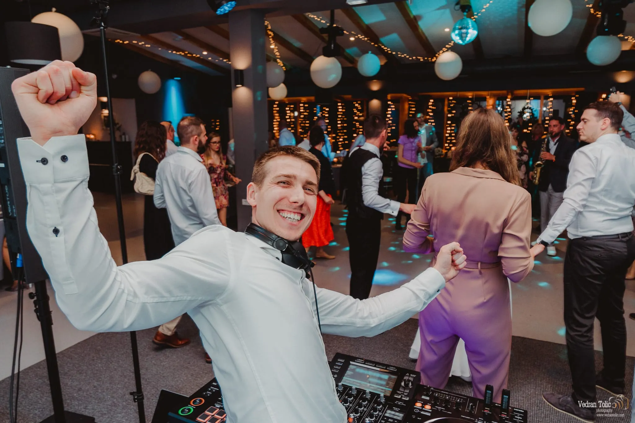 DJ Symart cheering with a full dance floor behind him