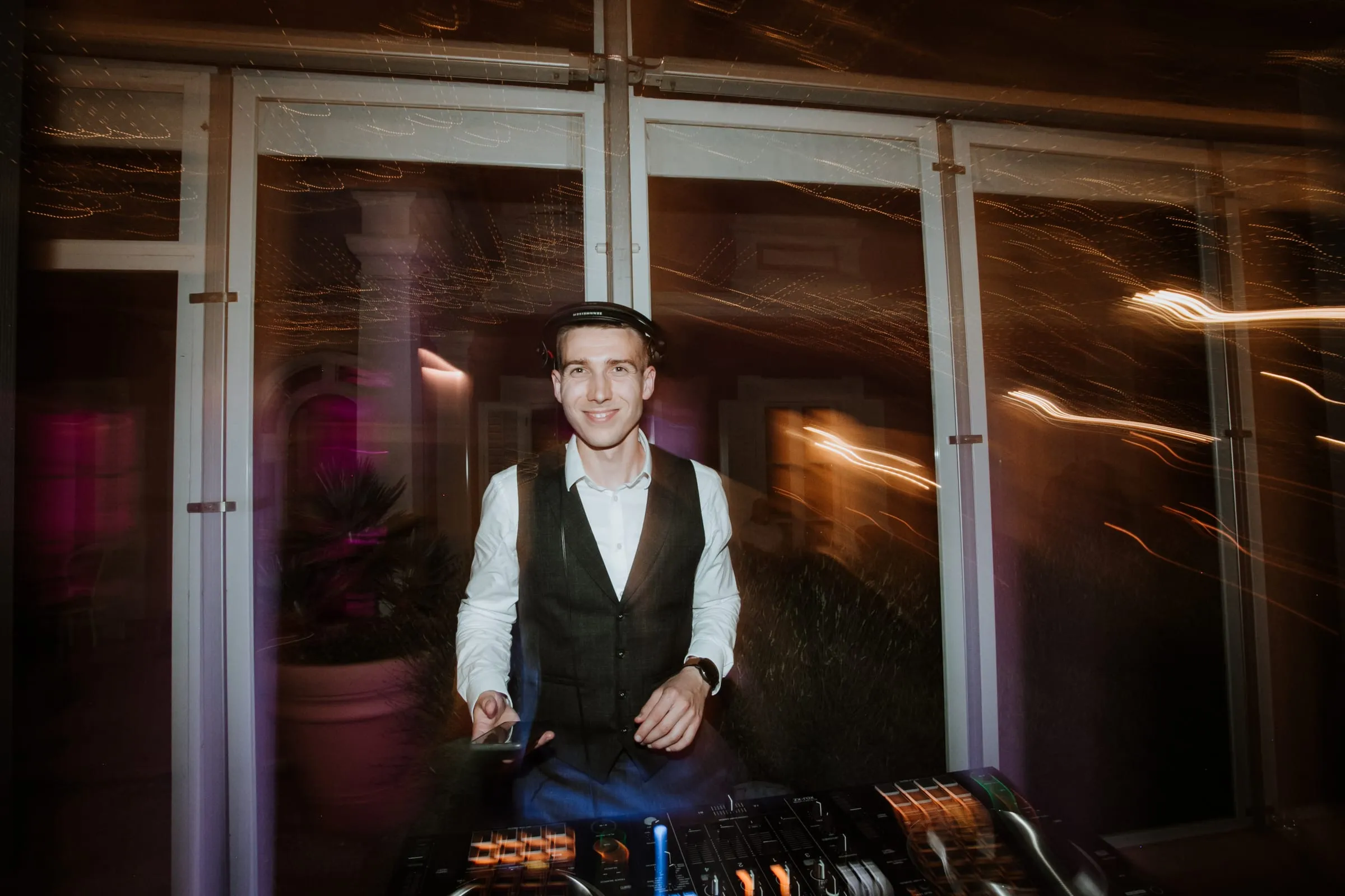 DJ Symart smiling at the decks with trails of light around him at Villa Polesini