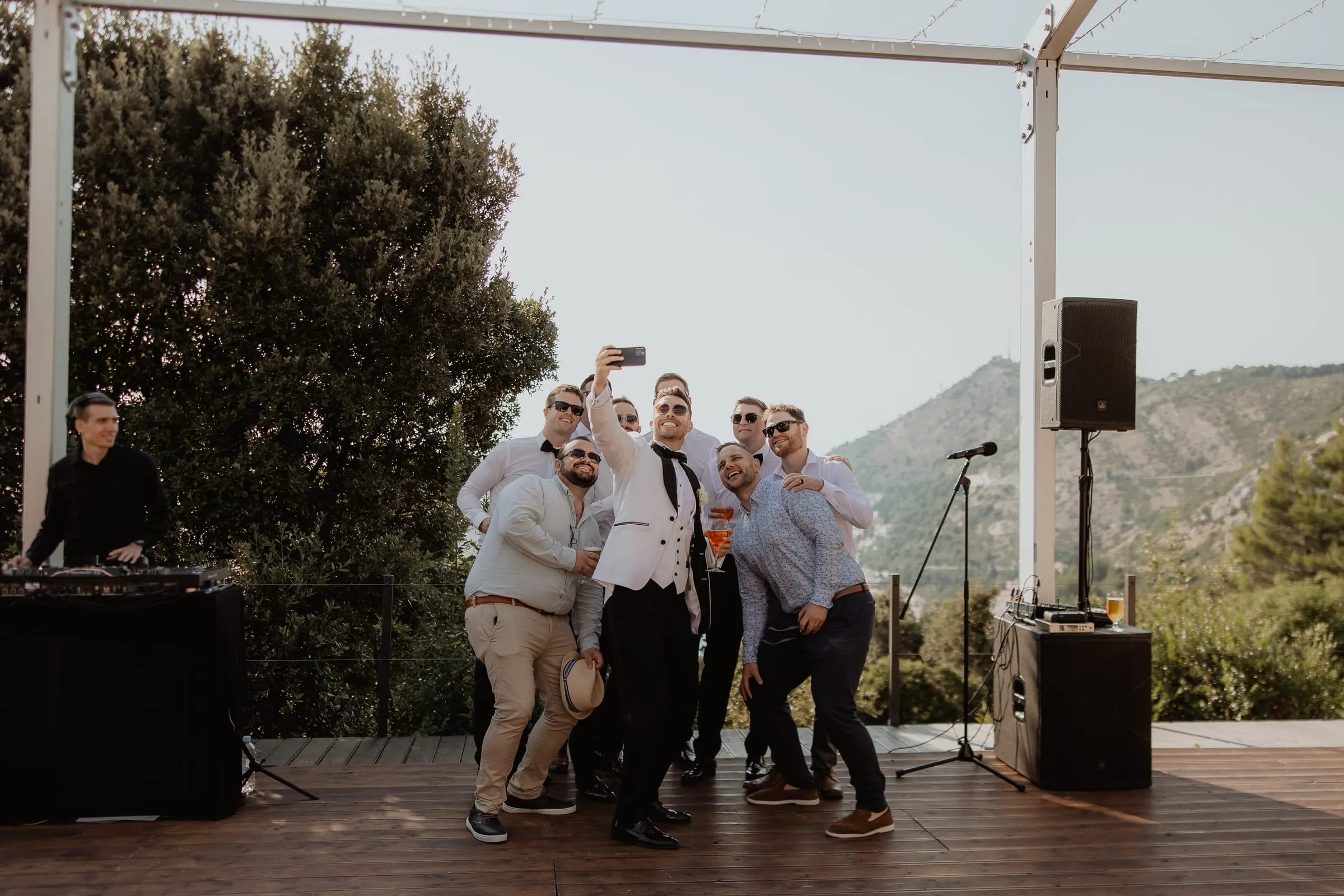 Guests dancing on a terrace with a view of the hills near Dubrovnik while DJ Symart plays